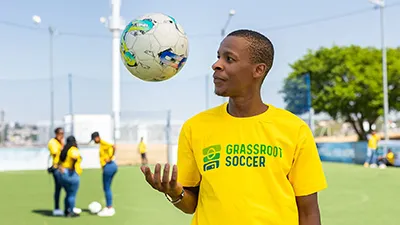 A photo of a Grassroot Soccer coach in a tshirt with our logo design.